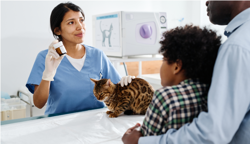 A vet shows a cat owner a prescription bottle