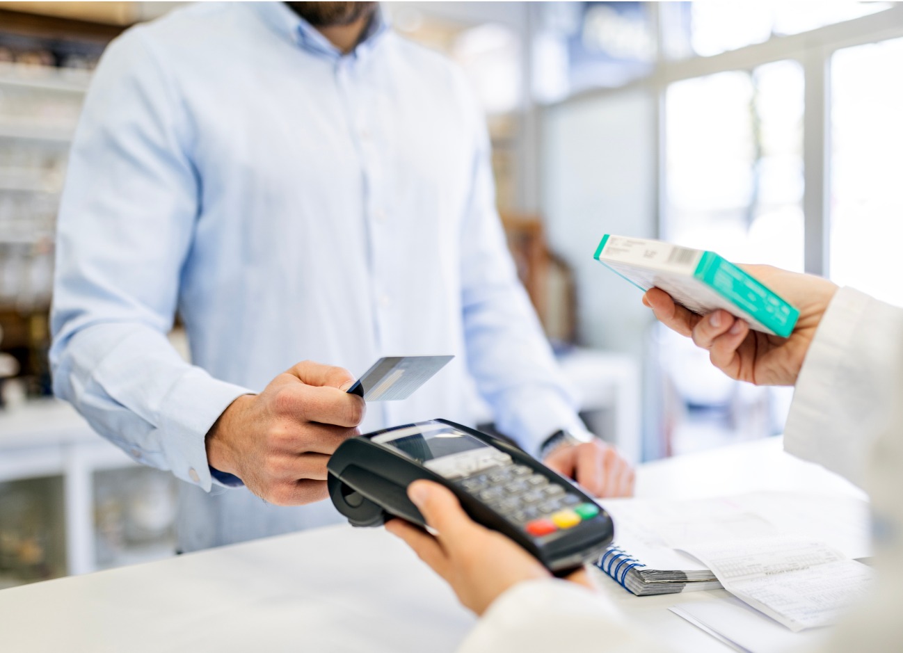 Man offering his payment card to a handheld point-of-sale device.