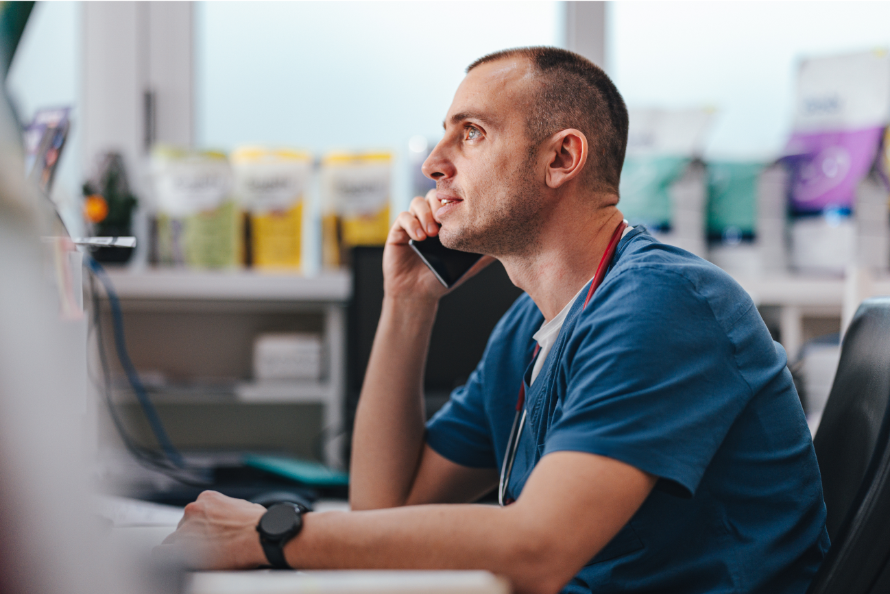 Male vet on the phone looking at computer screen