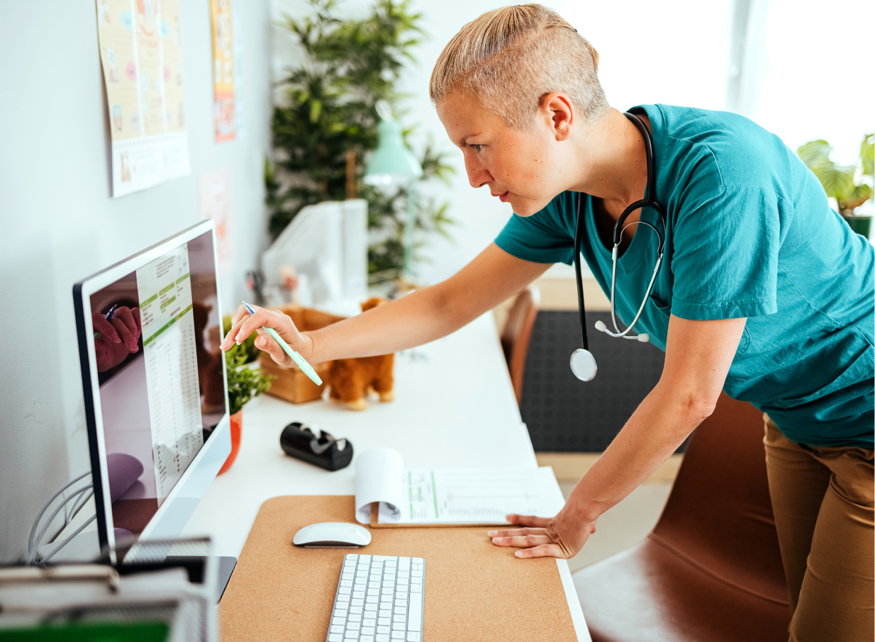 Vet looking at a desktop monitor