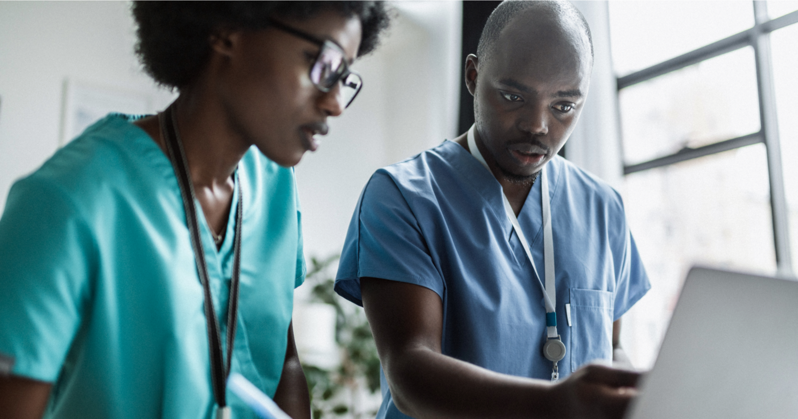 Two vets, a man and a woman, looking at a laptop in the foreground