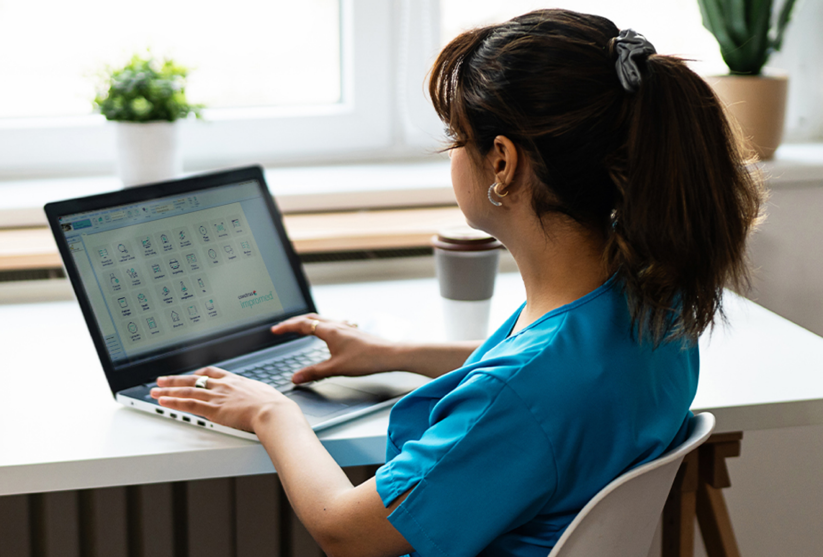 Vet writing on a laptop in front of a large bright window