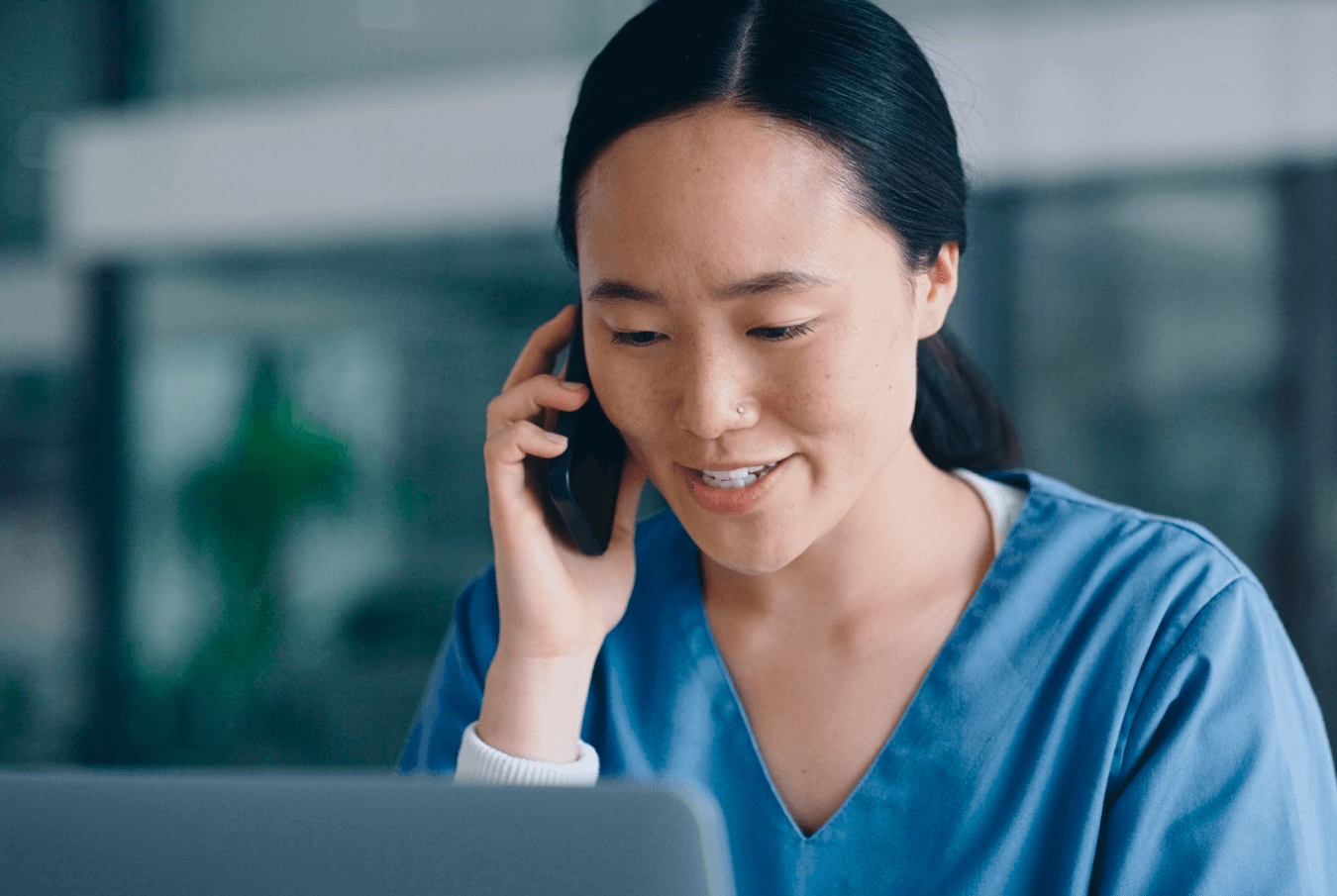 A female vet tech smiling while talking on a mobile phone.