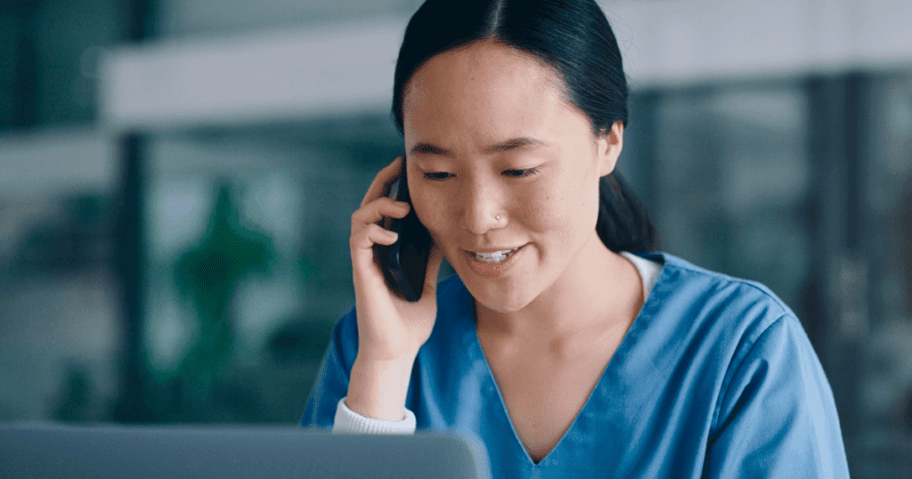 A female vet tech smiling while talking on a mobile phone.