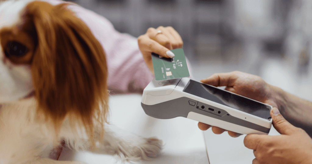 Pet owner with her dog making a credit card payment on a mobile point-of-sale device