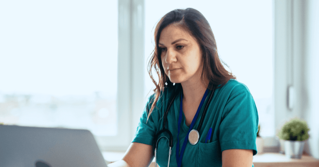 Vet entering data on her office laptop in a modern office setting