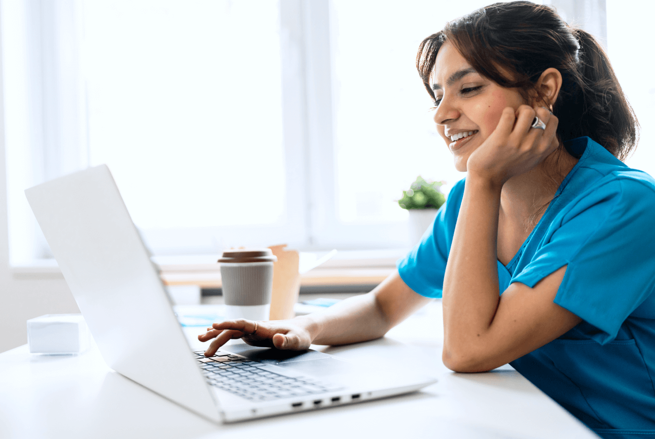 Smiling vet typing on a laptop keyboard