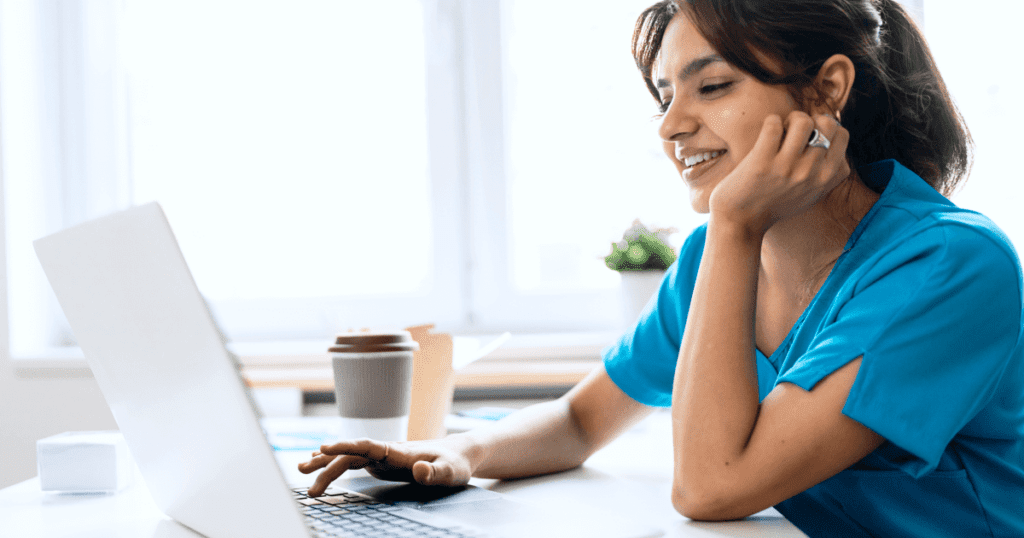 Smiling vet typing on a laptop keyboard