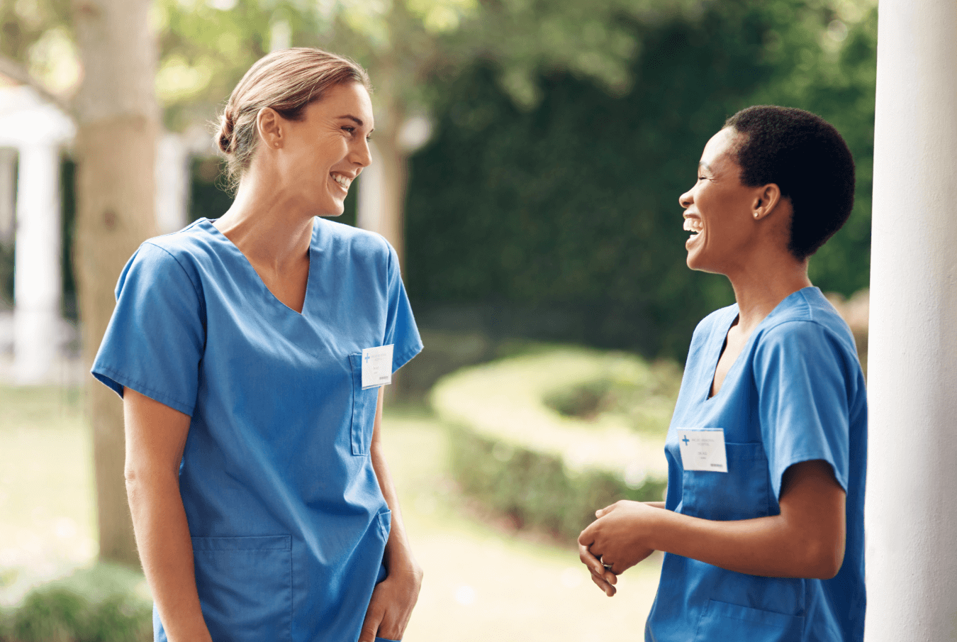 Two female vets standing outside laughing together