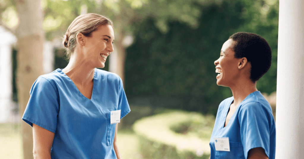 Two female vets standing outside laughing together