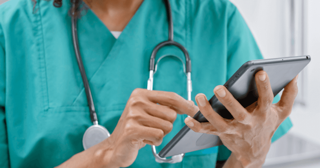 Vet with stethescope around her neck entering data into a tablet