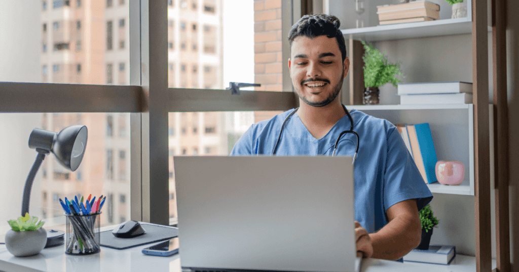 Smiling vet with stethoscope entering data on a laptop in a modern office